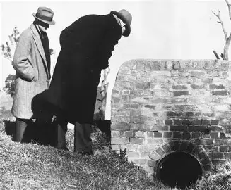 Police looking at the concrete drain where the body was found.