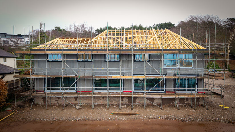 Large Custom House build with exposed block work and roofing structure.