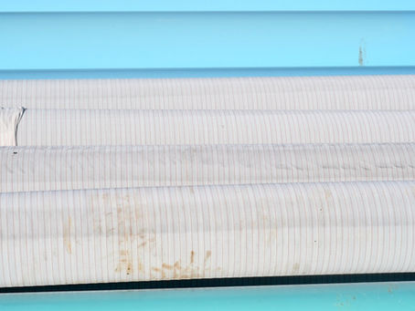 closeup of a striped pool cover with stains