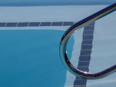Close up of pool handrail with blue water