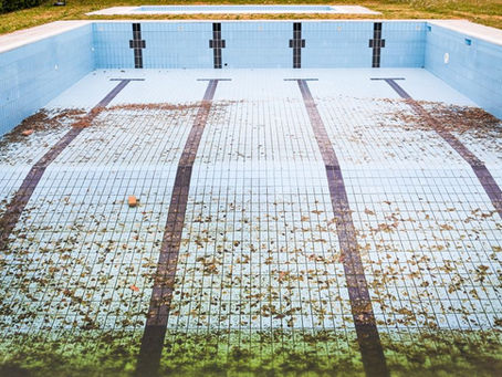 Unfilled pool with leaves and debris