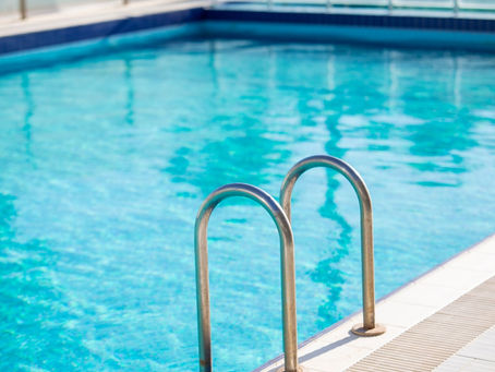 Clean outdoor swimming pool with metal ladder