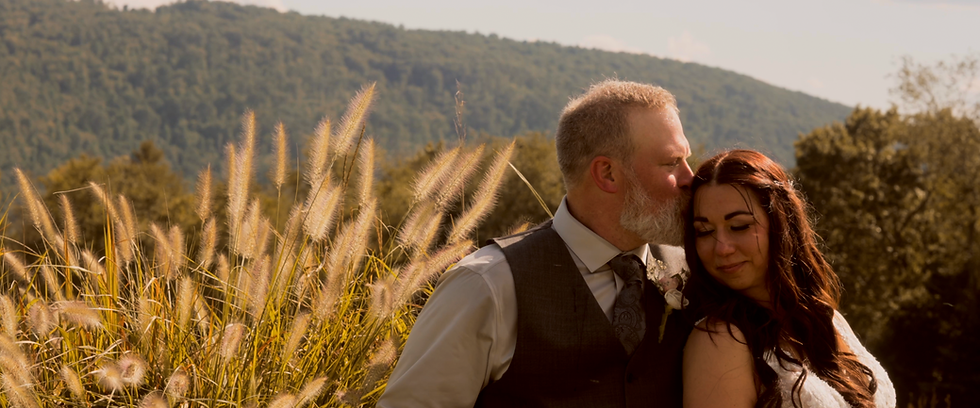 bride and groom kissing in a grassy field