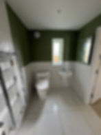 Modern bathroom with toilet, sink, and towel rail
