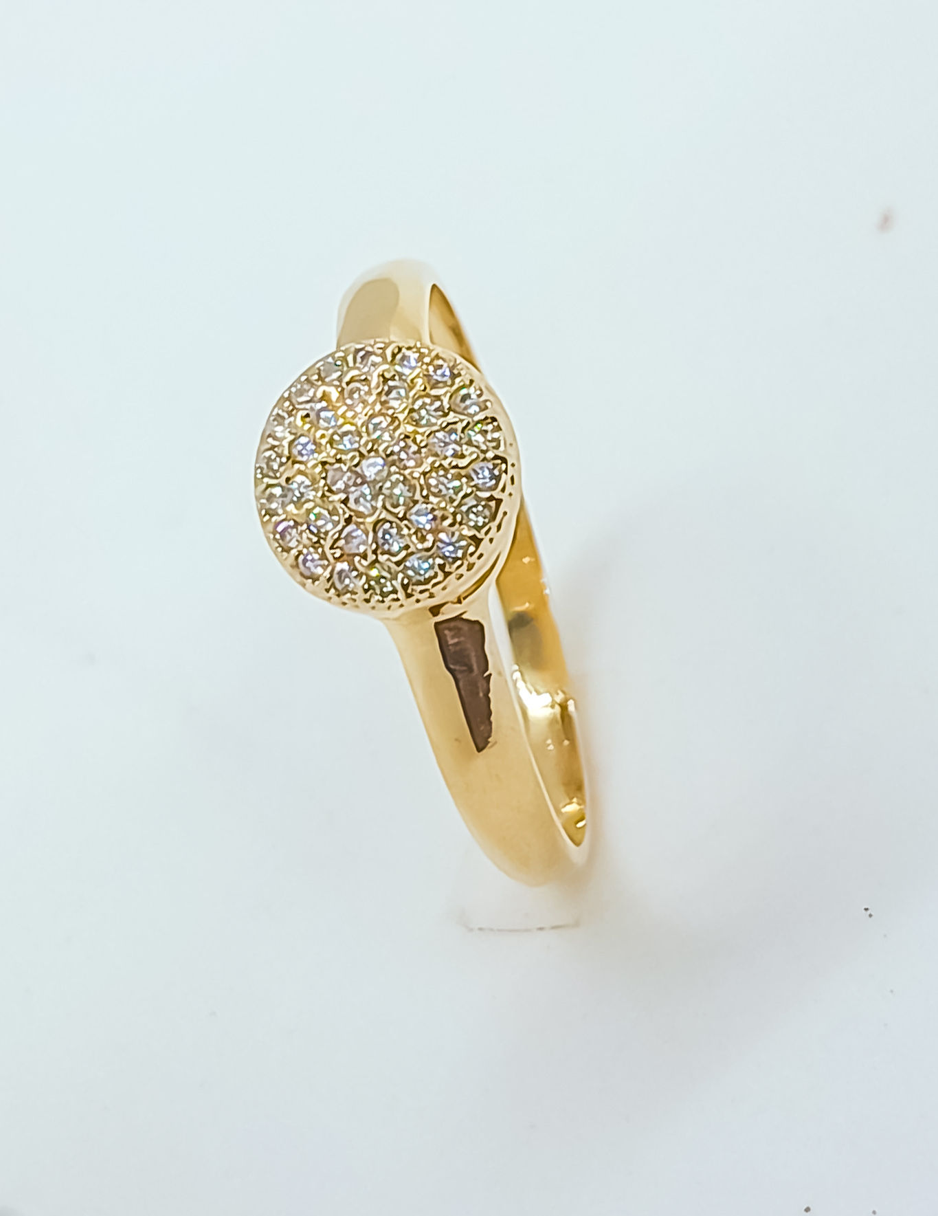 Anel dourado com topo redondo cravejado