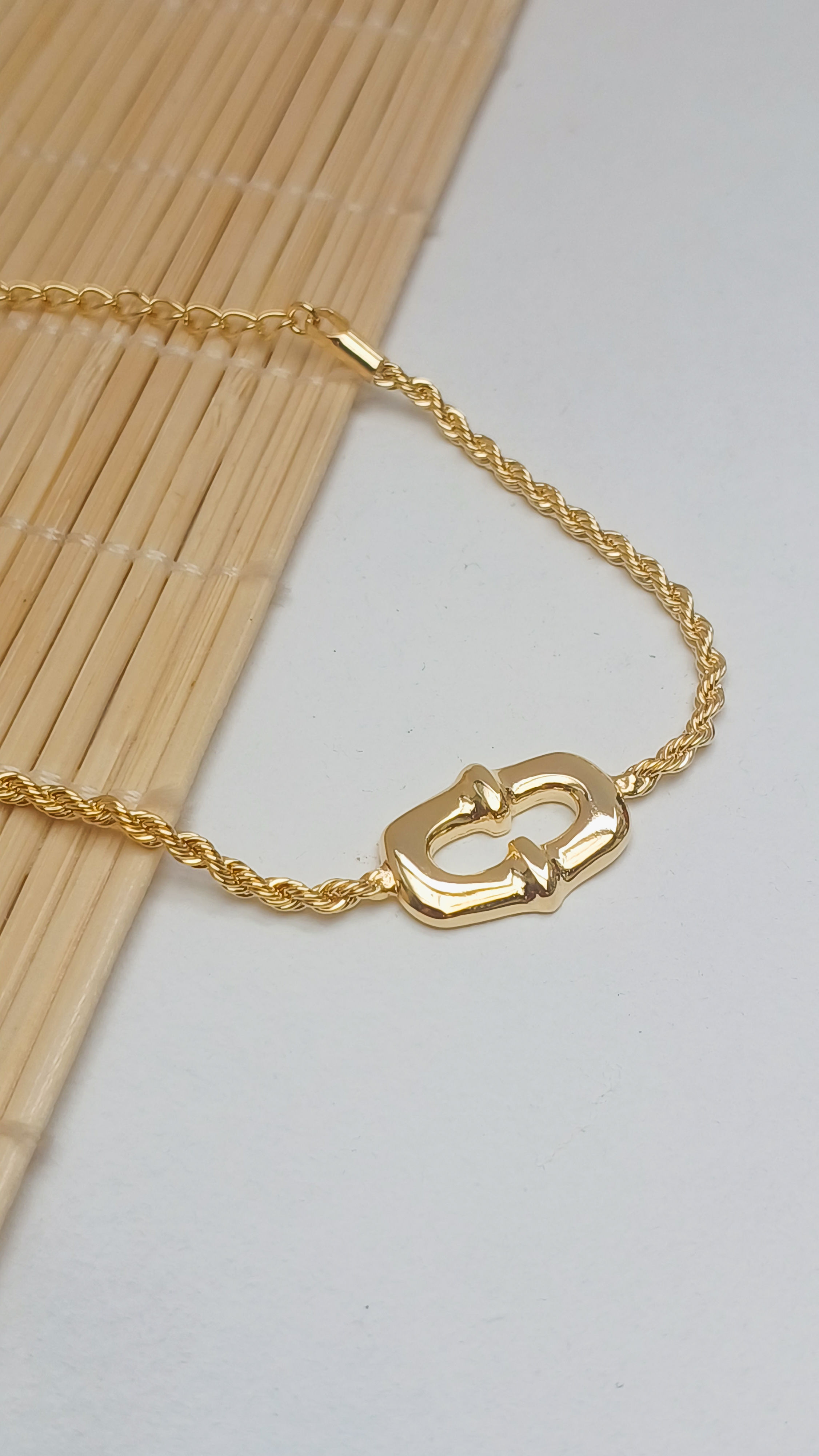 Pulseira torcida com detalhe quadrado