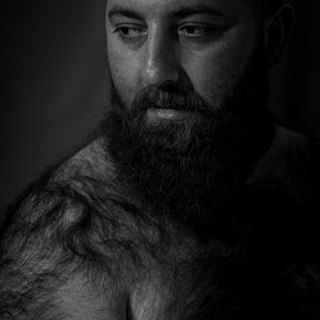 lifestyle boudoir portrait of a man with a lot of body hair