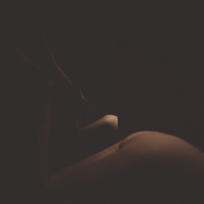 boudoir portrait of a woman lying on a table on her belly