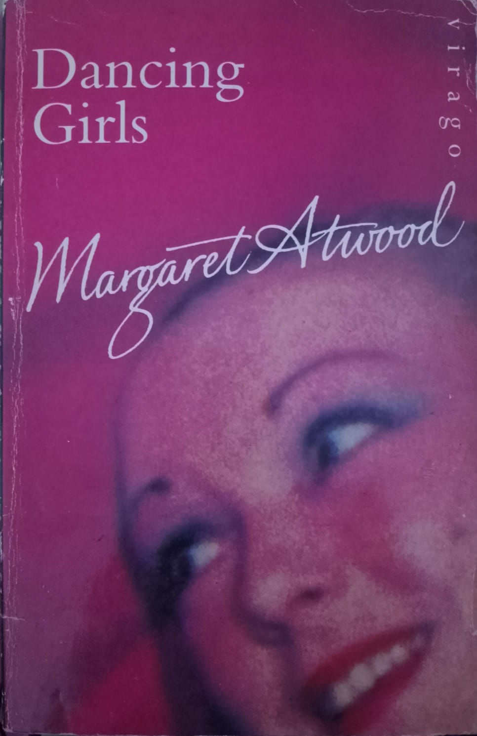 Margaret Atwood's book cover 'Girls', pink, featuring a partial freckled face.