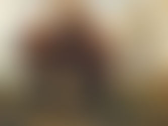 Autumn trees with orange leaves stand in a field under a cloudy sky. A solitary figure in black is in the background, creating a serene mood.