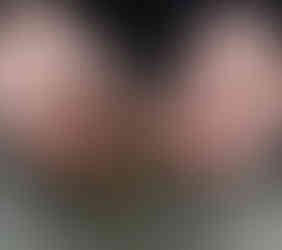 Hands carefully opening a stag bladder over a glass bowl on a wooden table. The setting is rustic and natural.