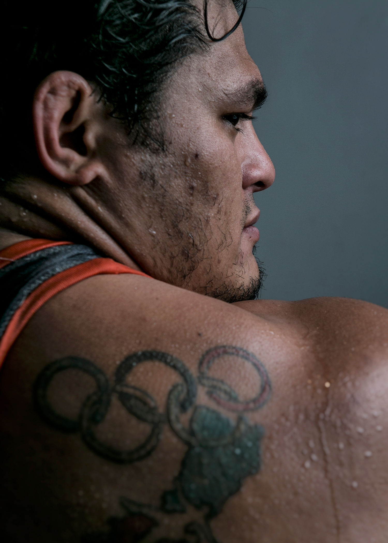 Portrait of Jeff Cobb from behind his shoulder tattooed with the Olympic Rings