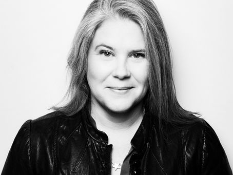 Heasdshot in black and white of woman looking straight to camera a slight smile