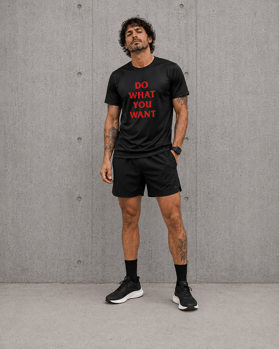 Male model wearing black Do What You Want running T-shirt with red gothic-style typography.