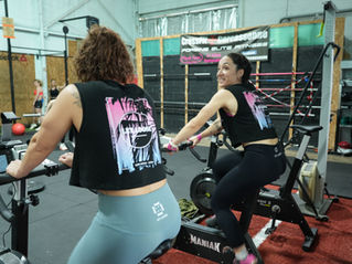 Deux femmes sur un vélo dans salle de fitness
