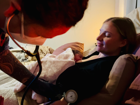Erica takes the blood pressure on a freshly tucked in postpartum mama before discharge.