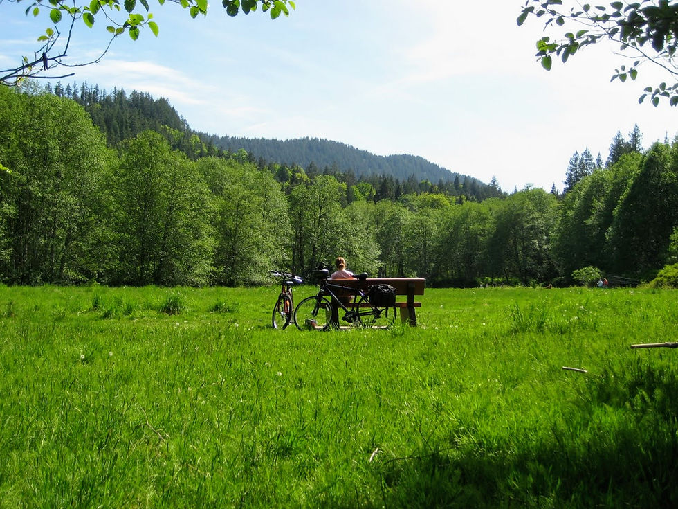 Lacey and her bike in a field on Bowen Island