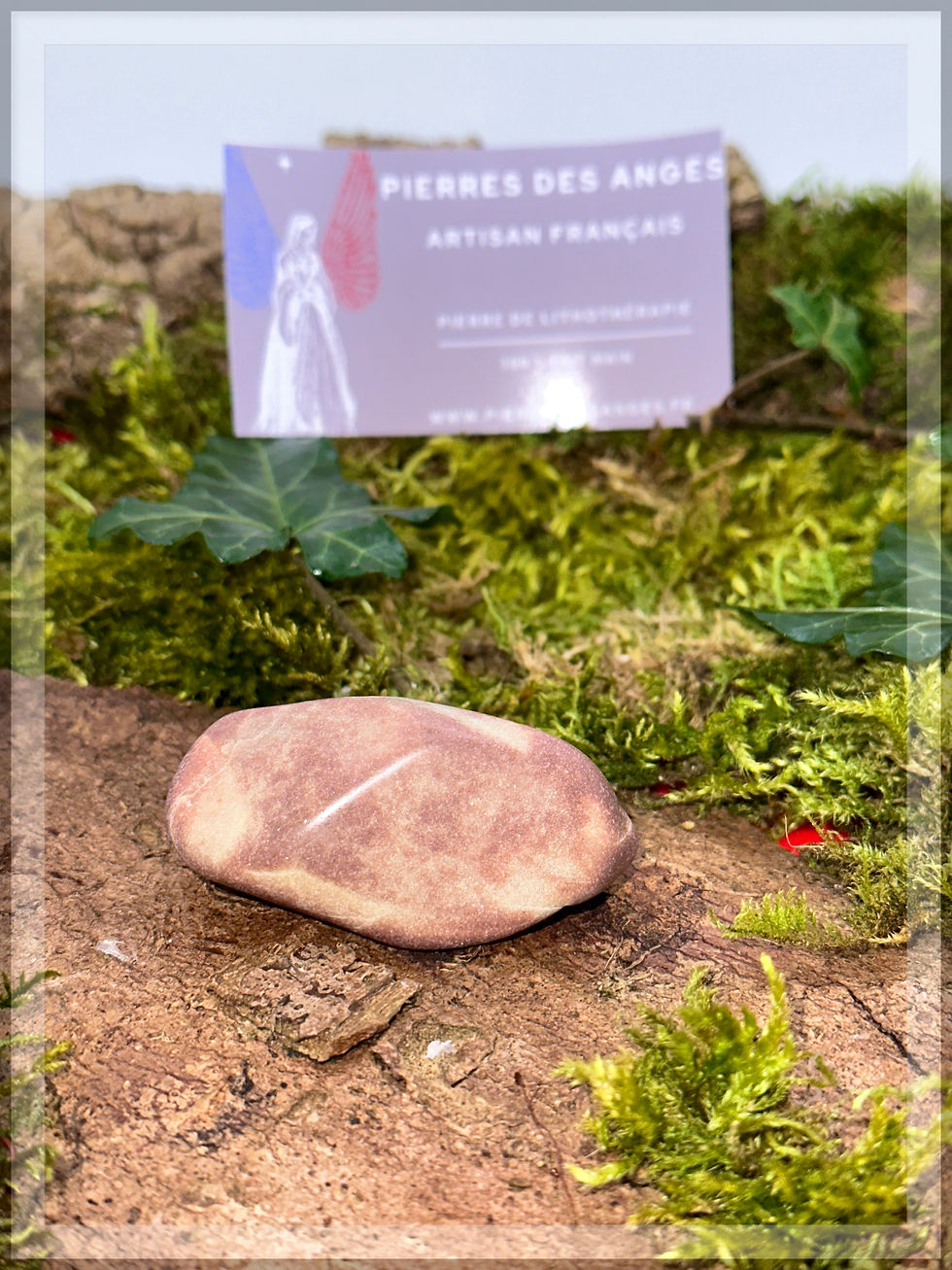 Pierre roulée posée sur de la mousse verte avec le texte Pierres des anges.