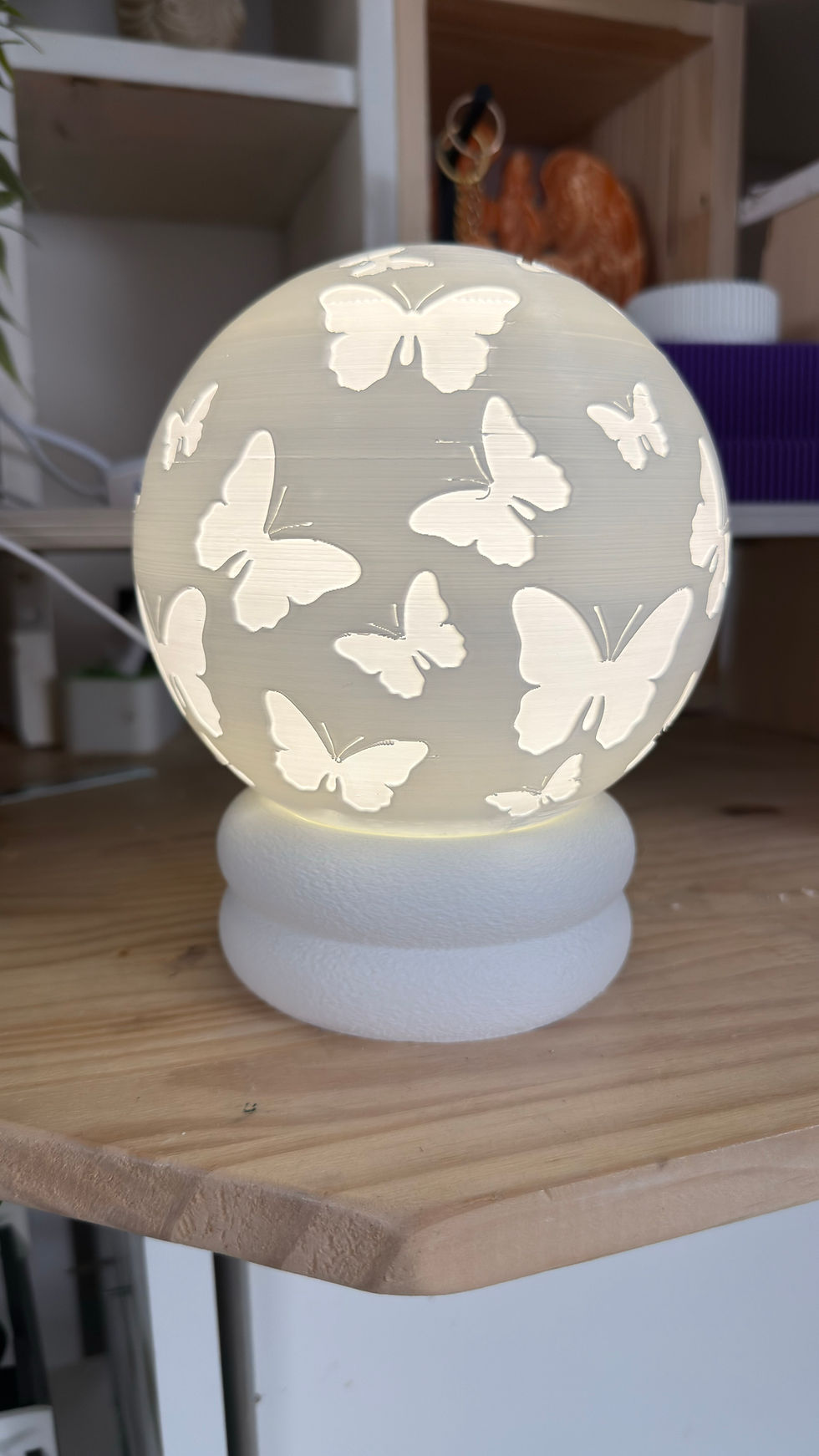 Lampe sphérique blanche avec motifs de papillons ajourés