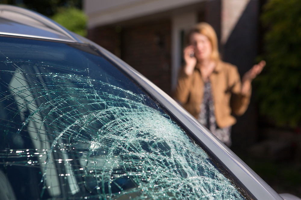 Woman Inspects Windshield Damage