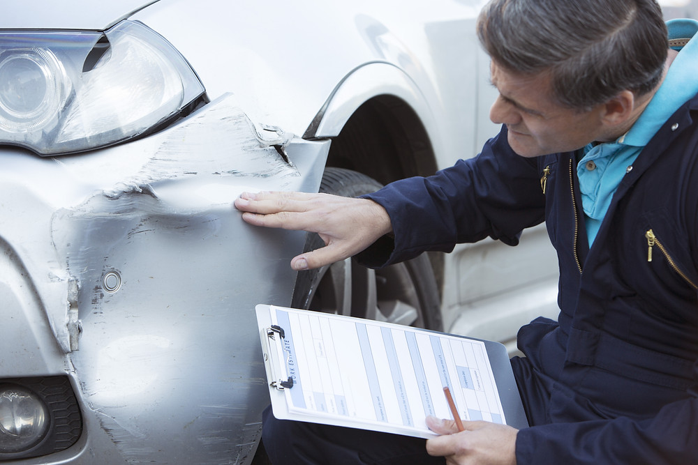 Man Inspects Collision Damage