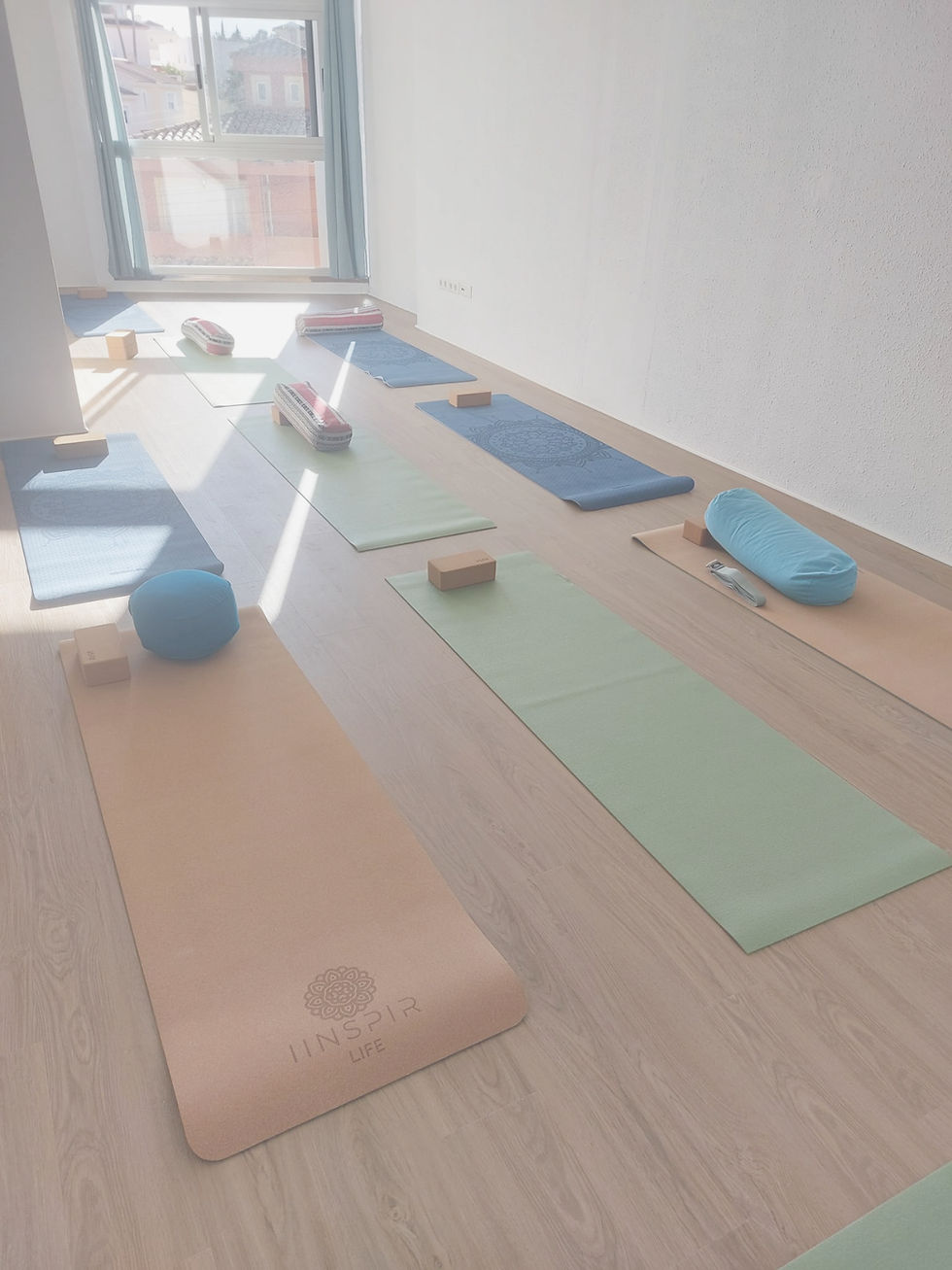 Eye-level view of a serene yoga studio in Alfaz del Pi with natural light and mats arranged neatly
