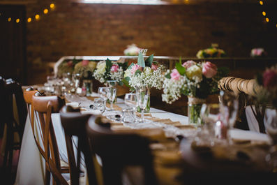 Wedding reception table with floral arrangements, glasses and background details. Craig Hickey Photo.