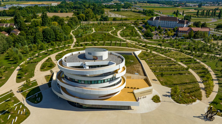Vue aérienne de la Cité des Climats et vins de Bourgogne, un bâtiment contemporain aux lignes circulaires, niché au cœur des vignobles. Un lieu dédié à la culture viticole, entre modernité et tradition.