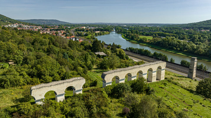 Vue panoramique de l’Aqueduc Romain de Jouy-aux-Arches surplombant la Moselle, vestige monumental de l’ingéniosité antique, entre patrimoine et nature.