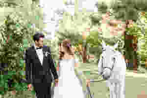 Bride and Groom take a white horse for a walk.