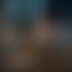 Uomo seduto alla scrivania di notte, circondato da documenti e appunti, lavora al computer con espressione stanca e concentrata sotto una luce soffusa.