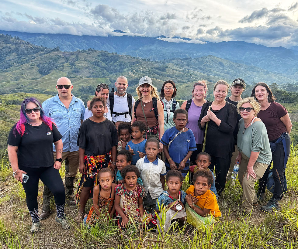 Visit Natives travellers, local guides and Asaro Mudmen posing together on a hillside in the Papua New Guinea Highlands.