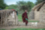 Maasai man standing in front of a traditional Maasai house in northern Tanzania