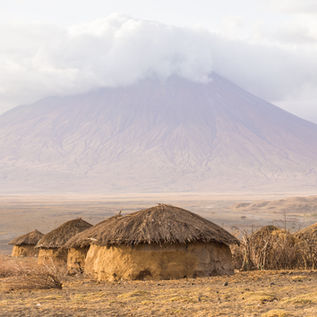 Maasai village in front of the Ol Doinyo Lengai (Mountain of God in the Maasai language),
