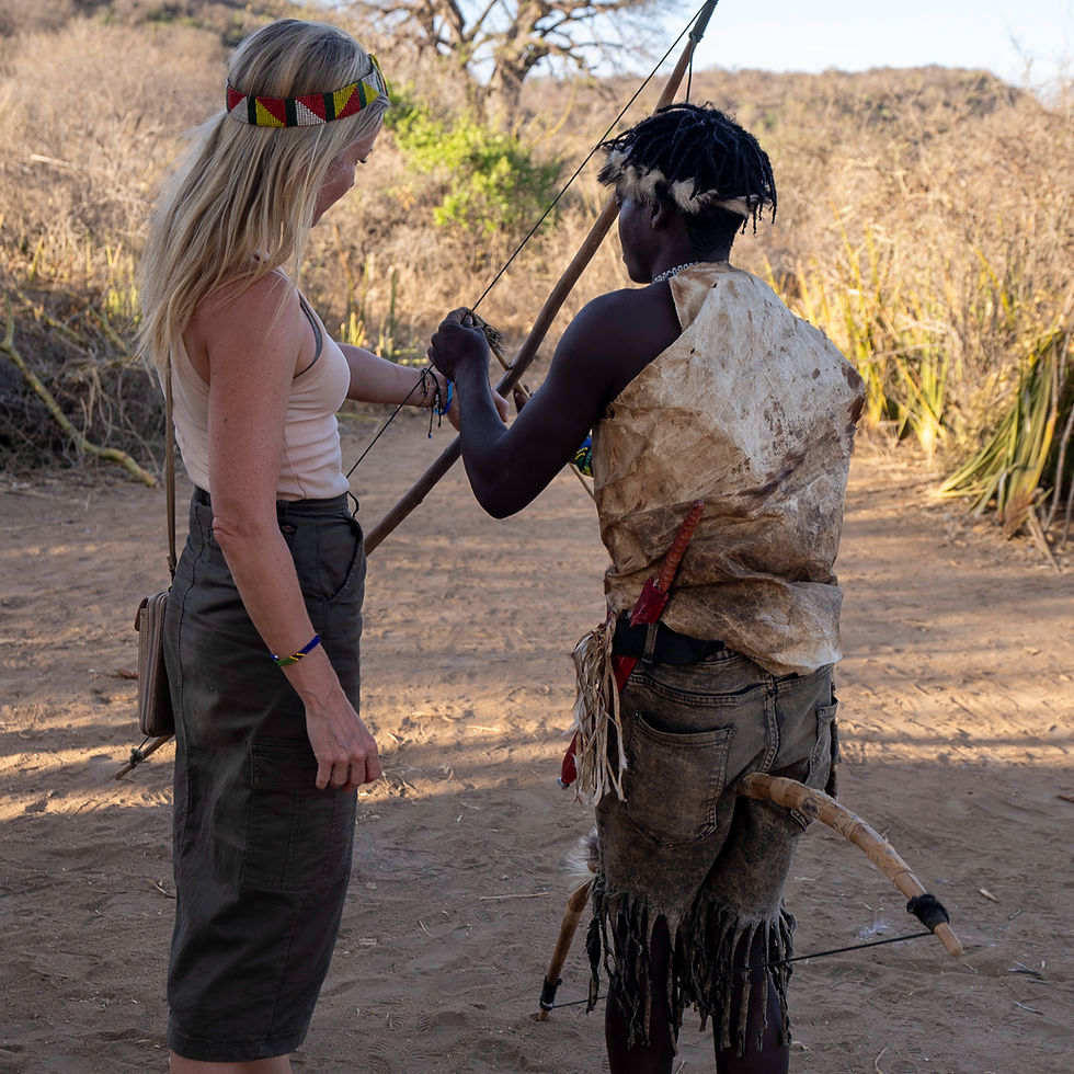 Traveler learning archery with a Hadzabe hunter in Tanzania near Lake Eyasi, authentic Hadzabe tribe cultural experience
