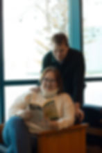 A cozy moment of a couple reading "In Cold Blood" together by a bright window