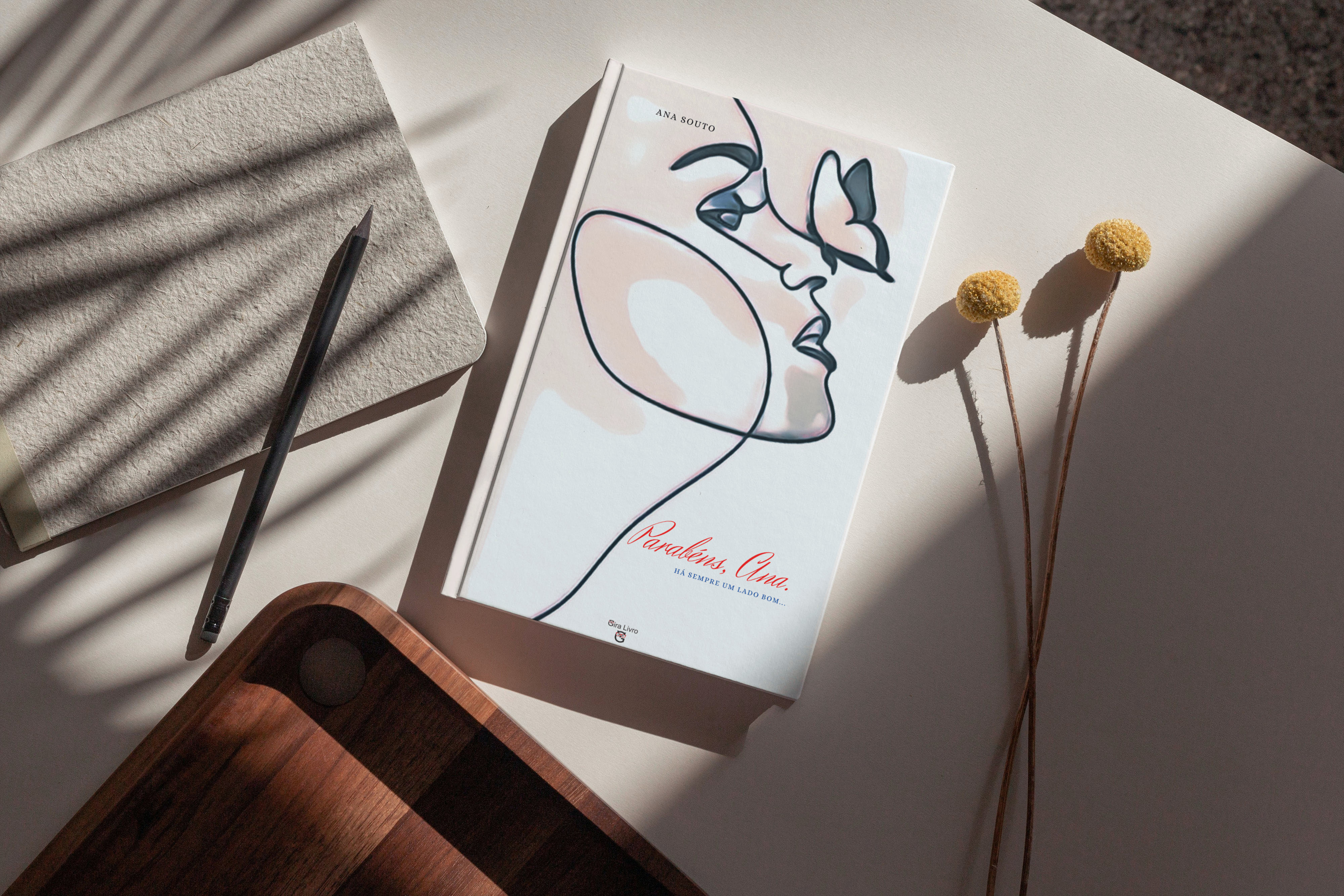 Livro Parabéns, Ana Há sempre um lado bom, sobre a mesa e duas flores amarelas. 