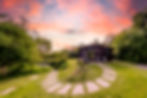 Glamping at a Cabin pink skies above and green lawn with winding path