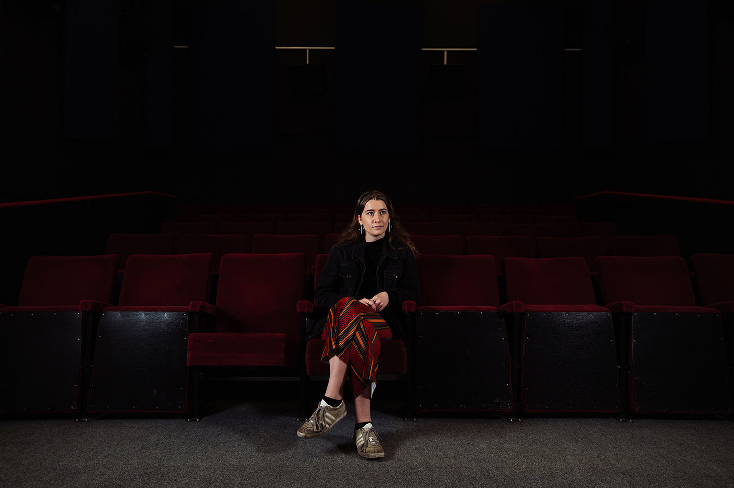 College prospectus photography, young woman in auditorium.