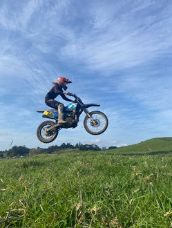 getting air as the rider jumps over a grassy hill
