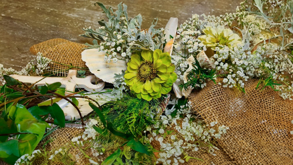 maritimer Tischschmuck für eine Hochzeit mit Muscheln, Schleierkraut, einem weissen Holzanker, Hanfbänder und grüner Zinnie