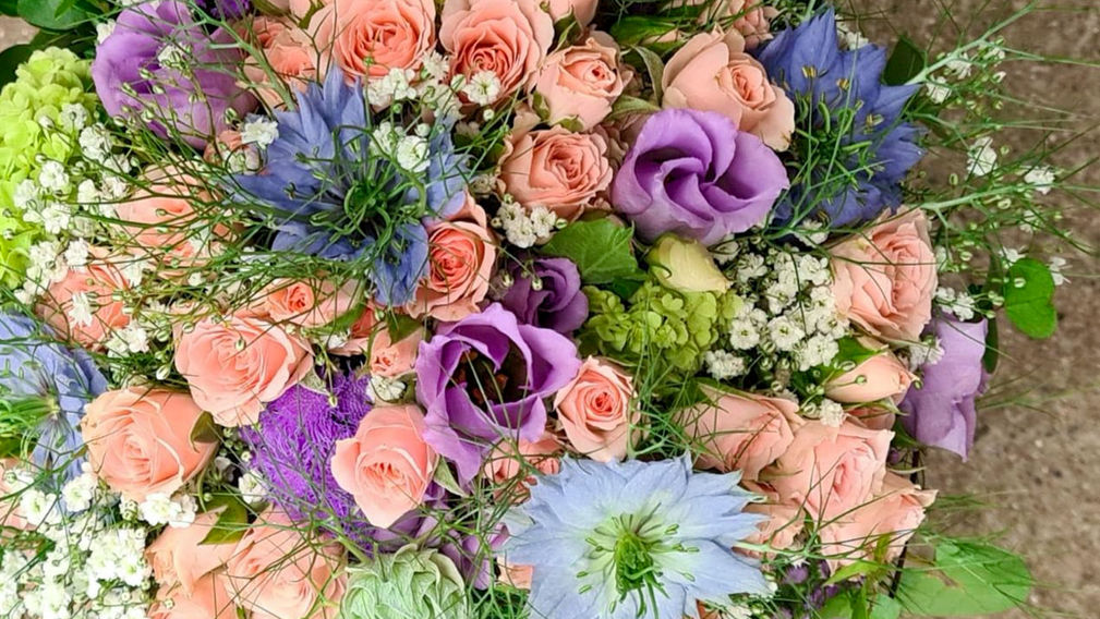 Hochzeitsstaruss mit rosafarbigen und violetten Rosen, grünen Hortensien, blauen Jungfern im Grünen und weissem Schleierkraut