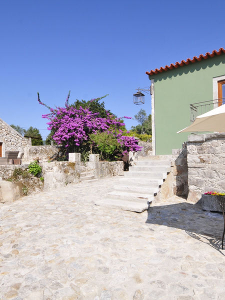 Steinhaus mit Treppe und Tisch im Freien. Schöne Aussicht bei hellem Sonnenschein.