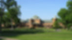 Golf and Country Club building surrounded by a green lawn and trees