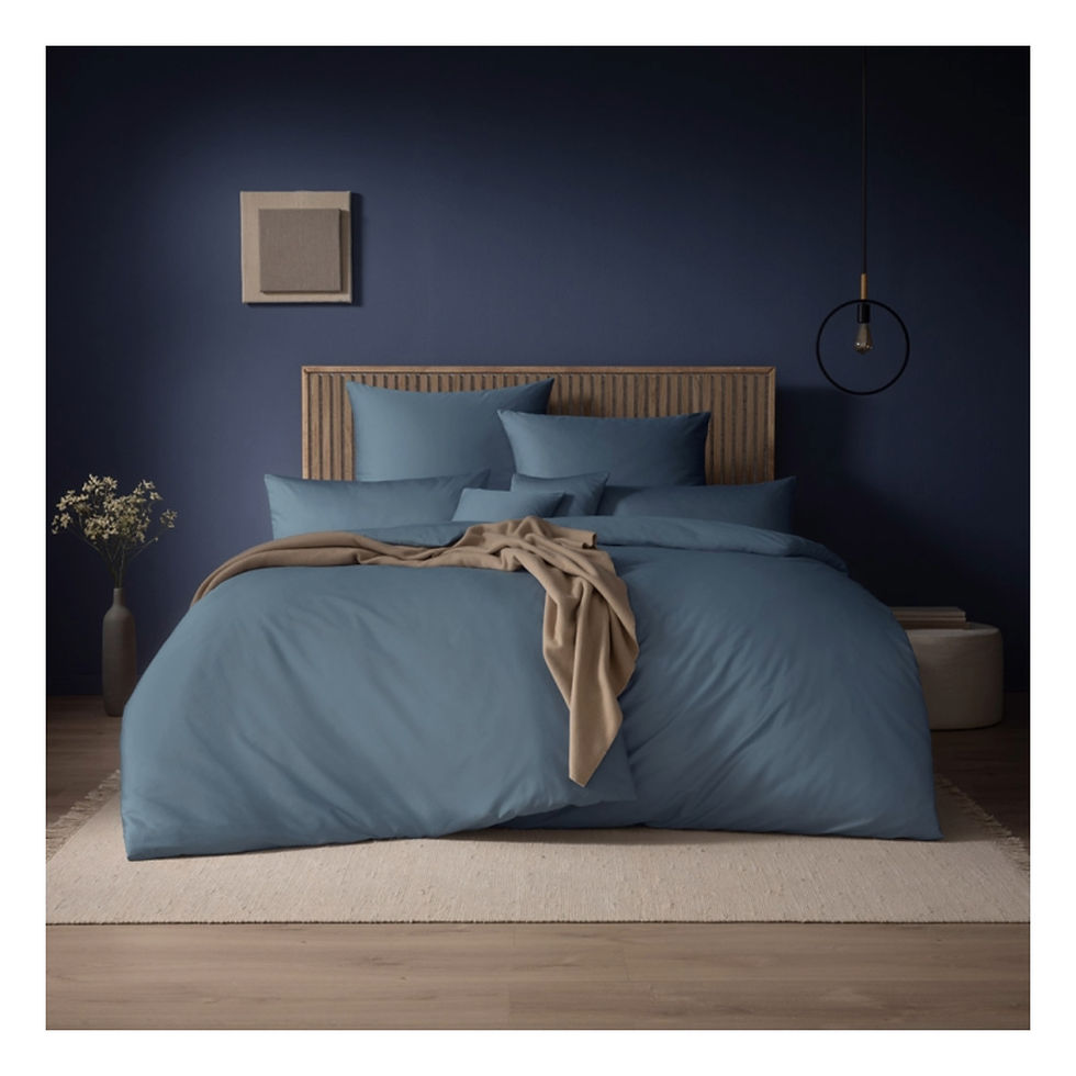 Bild eines Bettgestells mit einfarbiger Bettwäsche in Petrolgrün.