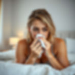 Frau im Bett, die sich die Nase ausschnauft.