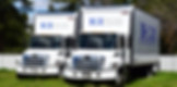 Two Executive Interiors moving trucks parked outdoors