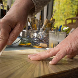 À Fontenay-sous-Bois, l’Atelier Rig & Léon redonne vie à des meubles chinés en les habillant de marqueterie de paille. La paille de seigle, découpée, teintée puis appliquée patiemment, révèle des reflets subtils et changeants selon la lumière. Attachée à valoriser chaque fragment de matière, l’artisane utilise les chutes de paille pour créer une collection de bijoux, prolongeant ainsi le geste créatif dans des pièces plus intimes. Ses créations mêlent tradition et inventivité, pour offrir des objets décoratifs et accessoires uniques, où la simplicité d’un matériau naturel devient une véritable source d’élégance.