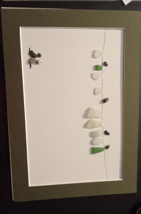 Petits Pebbles Oeuvres de galets et de verre polis par la mer de Louiza Nazef dans les Yvelines. Mon aventure artistique a commencée il y a quinze ans, en Floride, dans un geste partagé avec mon fils. Quelques galets oubliés, ramassés au bord de la mer, ont retrouvé souffle entre nos mains. De ce jeu est née une passion, une voix silencieuse faite de verres polis, de bois flottés et de poésie minérale. De l’Algérie à Malte, aux rivages méditerranéens, je glane mes trésors, offrandes naturelles devenues les joyaux de mes tableaux. Installée en France depuis plusieurs années, j’ai pu exposer à la Théière Apprivoisée, rejoindre le collectif Au Fil de l’Art de Carrières-sur-Seine, mener des ateliers à l’École des Alouettes, participer à des marchés d’art et présenter mes œuvres à la Mairie de Bonnières. Aujourd’hui, à l’Atelier 36 de la ville de Houilles, je continue d’exposer plusieurs fois par an. Mon art, né d’un instant suspendu, trace depuis un chemin de douceur,