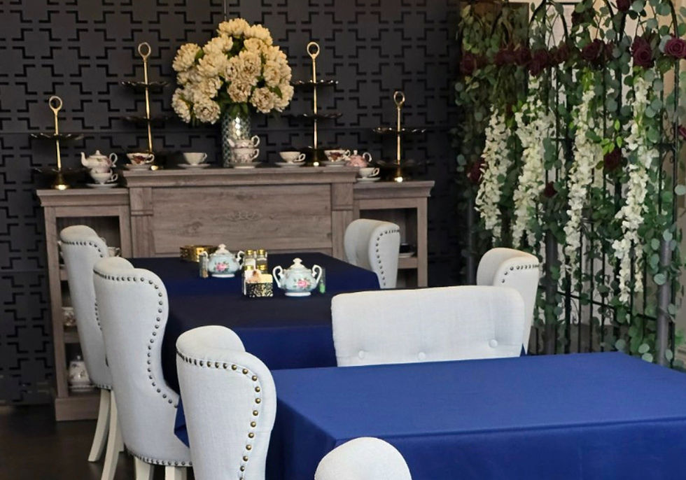 Panache Tea Boutique tearoom in Waterloo, Iowa with navy table settings, white upholstered chairs, and elegant afternoon tea display